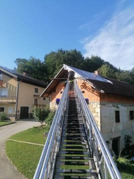 Gasilci med prekrivanjem poškodovane strehe